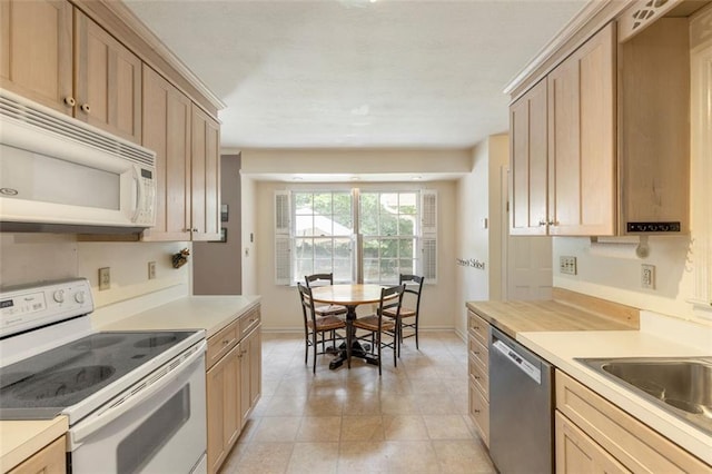 kitchen featuring white appliances, light countertops, baseboards, and light brown cabinets