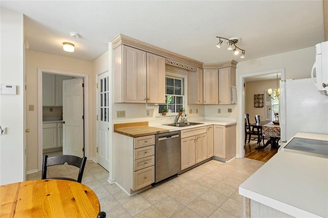 kitchen with white appliances, a sink, light brown cabinets, and a chandelier
