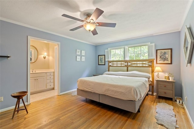 bedroom featuring light wood-style flooring, ornamental molding, baseboards, ensuite bath, and a ceiling fan