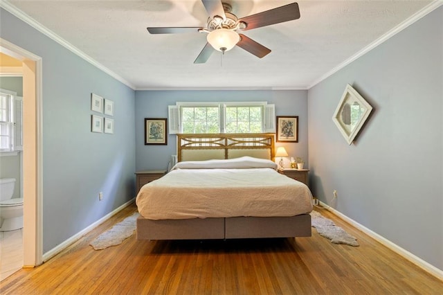 bedroom featuring wood finished floors, baseboards, connected bathroom, crown molding, and a ceiling fan