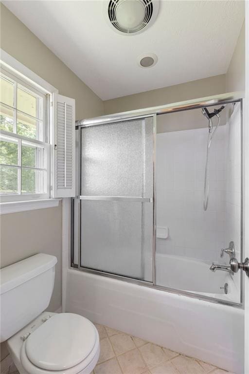 full bathroom featuring toilet, bath / shower combo with glass door, and tile patterned floors