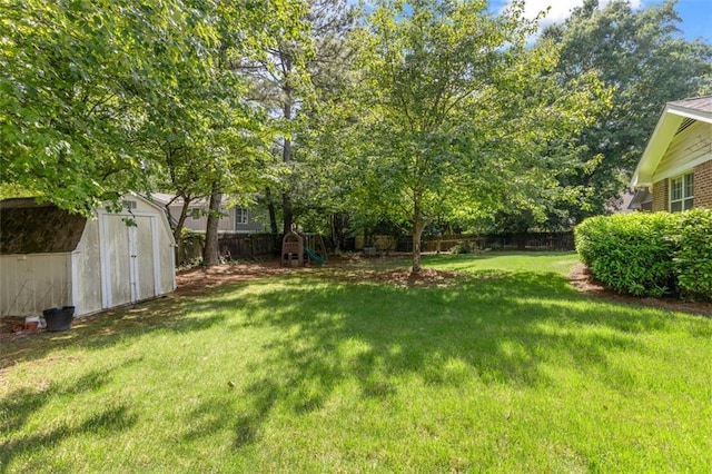 view of yard with a storage shed, a playground, and an outdoor structure