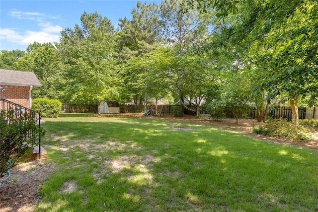 view of yard with a storage shed, an outbuilding, and a playground