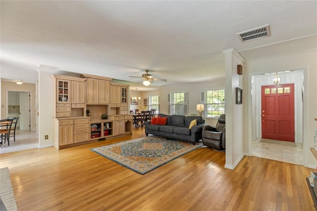 living area featuring light wood-type flooring, a ceiling fan, and baseboards