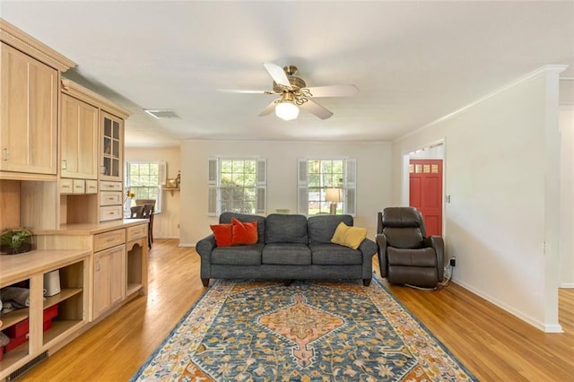 living area featuring ceiling fan, light wood-type flooring, and baseboards
