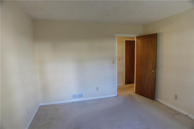 carpeted spare room featuring a textured ceiling