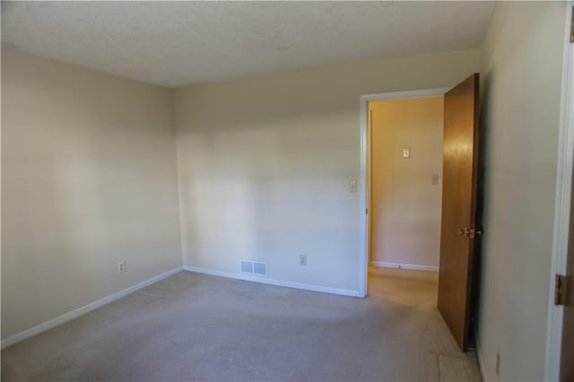 carpeted empty room with a textured ceiling