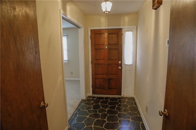 carpeted foyer entrance featuring plenty of natural light