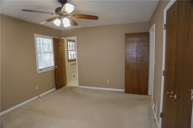 unfurnished bedroom with a closet, light colored carpet, and ceiling fan