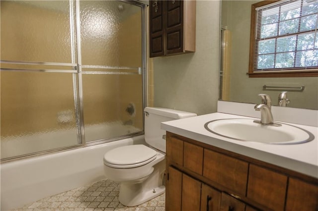 full bathroom with vanity, bath / shower combo with glass door, and toilet