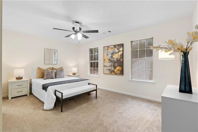 bedroom with baseboards, light carpet, and visible vents