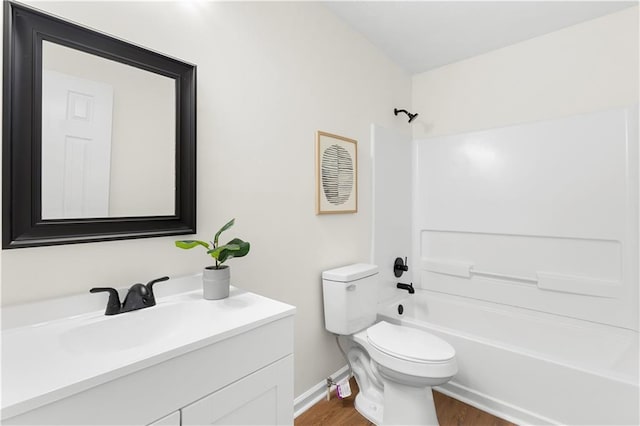 full bath featuring wood finished floors, vanity, baseboards, toilet, and  shower combination