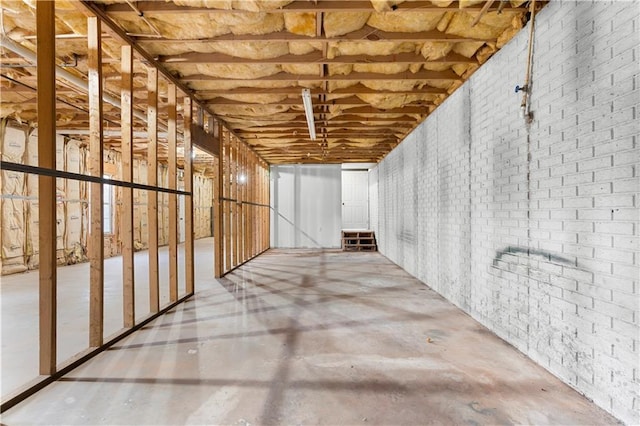 interior space with concrete flooring and brick wall