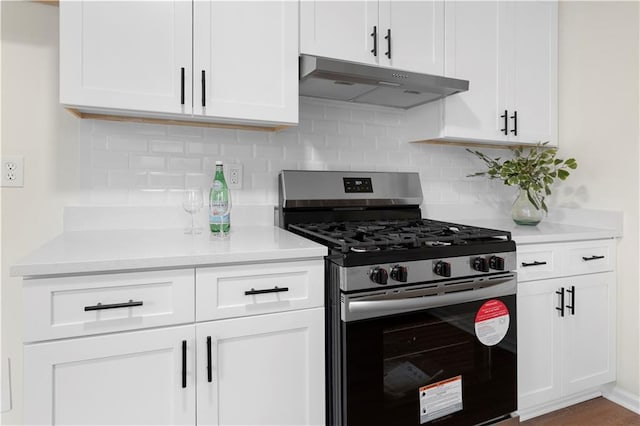 kitchen featuring under cabinet range hood, white cabinets, gas stove, and light countertops