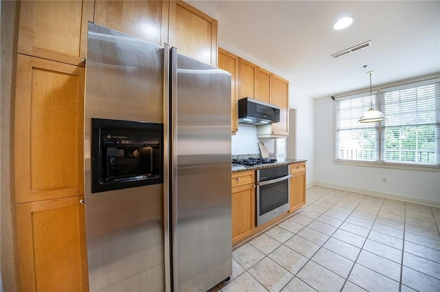 kitchen featuring light tile patterned floors, baseboards, visible vents, decorative light fixtures, and stainless steel appliances