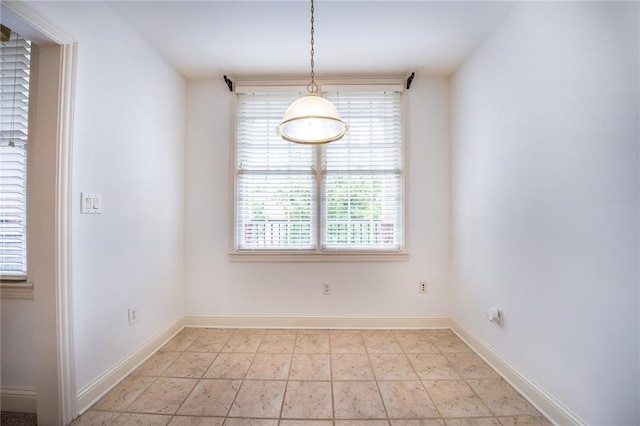 unfurnished dining area featuring baseboards