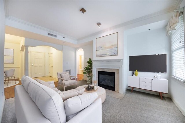 unfurnished living room with a fireplace, light carpet, a healthy amount of sunlight, and crown molding