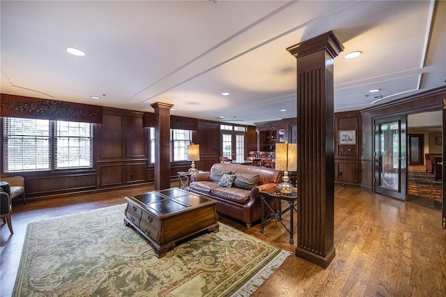 living area featuring recessed lighting, ornate columns, and wood finished floors