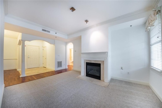 unfurnished living room featuring a fireplace, visible vents, and crown molding