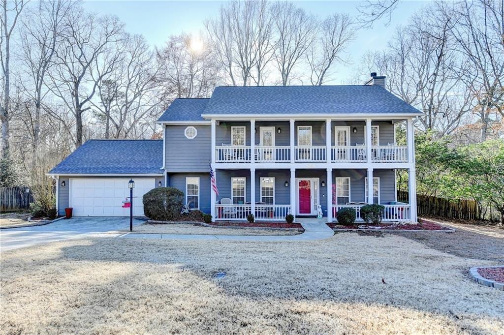 view of front of house featuring a balcony, a garage, and covered porch