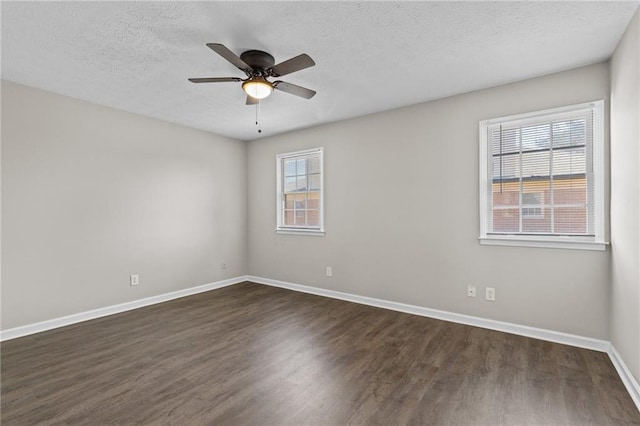 empty room with dark wood finished floors, a textured ceiling, baseboards, and a ceiling fan