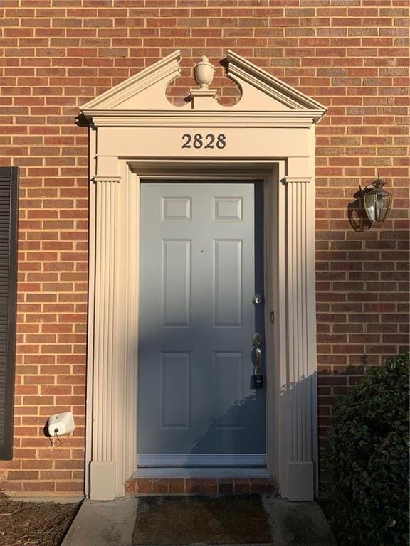 entrance to property featuring brick siding