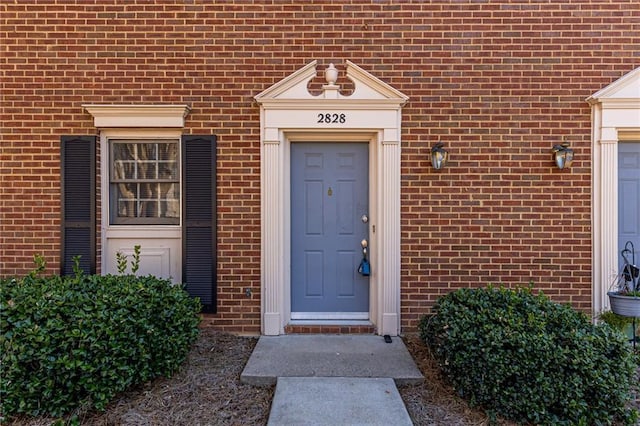 view of exterior entry featuring brick siding