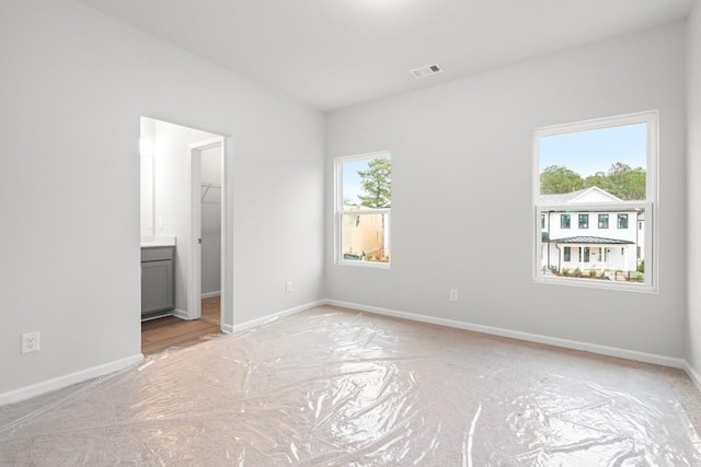 unfurnished bedroom featuring a walk in closet and a closet