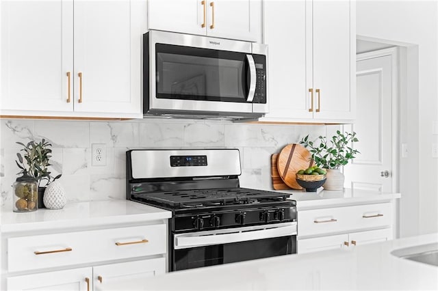 kitchen featuring backsplash, white cabinets, and stainless steel appliances