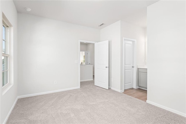 unfurnished bedroom with light colored carpet