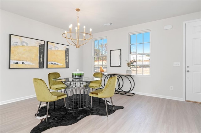 dining room featuring hardwood / wood-style flooring and an inviting chandelier