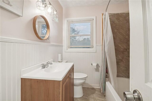 full bathroom featuring tile patterned flooring, vanity, toilet, and shower / bathtub combination with curtain