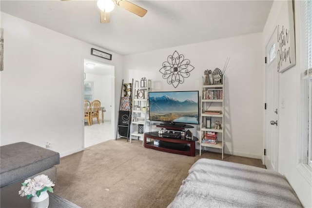 carpeted living room with ceiling fan