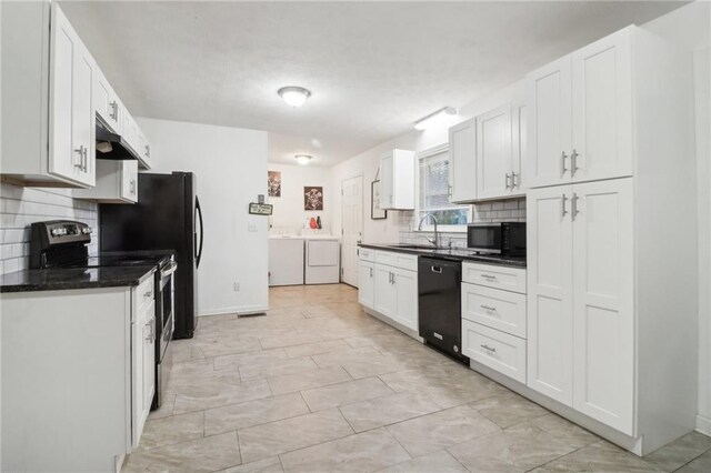 kitchen featuring white cabinetry, sink, washing machine and dryer, decorative backsplash, and black appliances