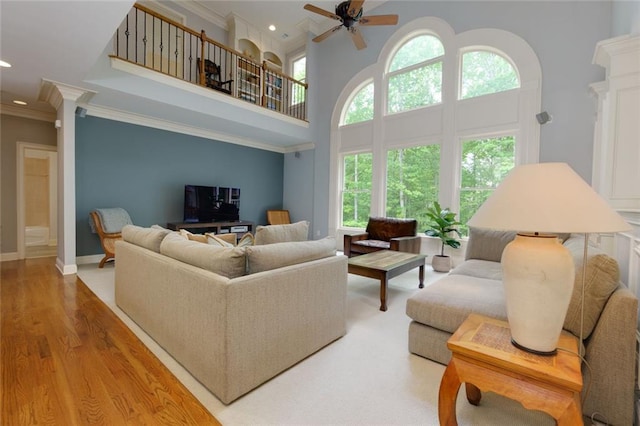 living area with crown molding, ceiling fan, and a healthy amount of sunlight