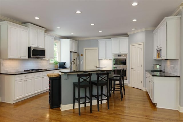kitchen featuring crown molding, appliances with stainless steel finishes, backsplash, and dark countertops