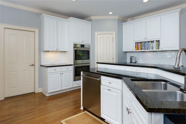 kitchen featuring white cabinets, stainless steel appliances, recessed lighting, and a sink