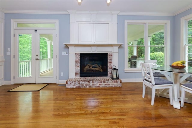living room featuring baseboards, ornamental molding, and light wood finished floors