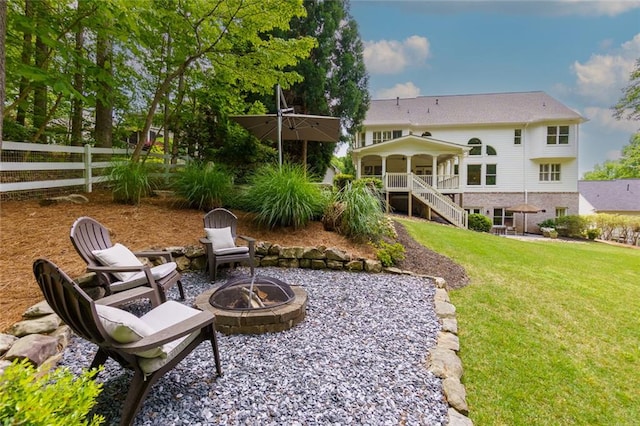 view of yard featuring fence, a fire pit, and stairway