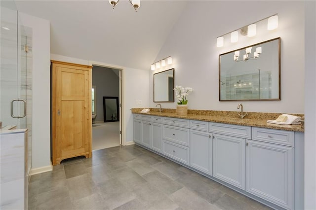 full bath with double vanity, a shower stall, a sink, and lofted ceiling