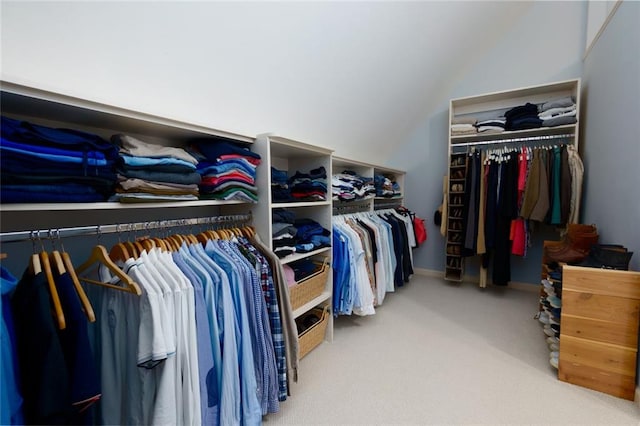 walk in closet with carpet and lofted ceiling
