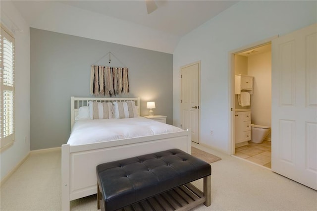 bedroom featuring light colored carpet, ensuite bath, a ceiling fan, baseboards, and vaulted ceiling