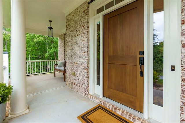 property entrance with brick siding and covered porch