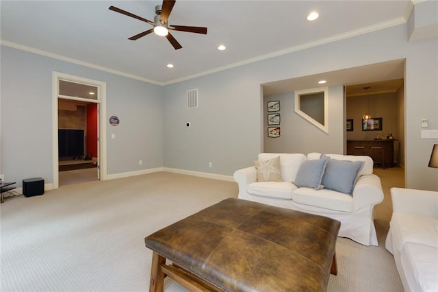 living room featuring ceiling fan, visible vents, ornamental molding, and light carpet