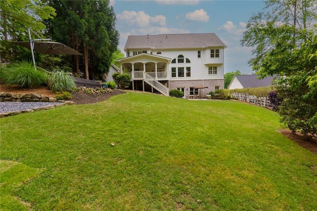 rear view of house with a yard and stairway