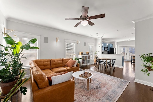 living area featuring dark wood-style floors, ceiling fan, baseboards, and ornamental molding