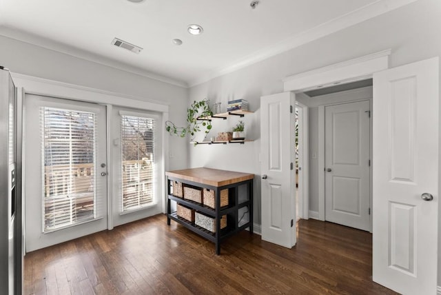 entryway featuring baseboards, visible vents, dark wood finished floors, and crown molding