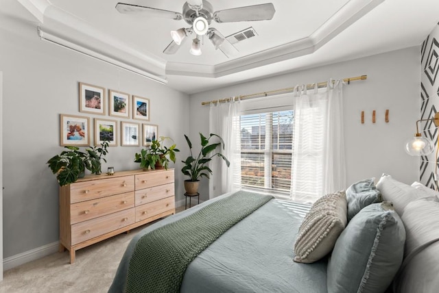 bedroom featuring a raised ceiling, light colored carpet, visible vents, ceiling fan, and baseboards