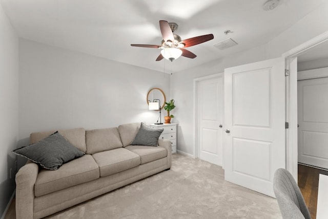 living room with light carpet, ceiling fan, and baseboards