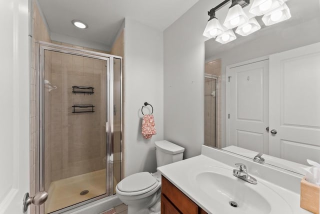 full bathroom featuring a shower stall, toilet, and vanity